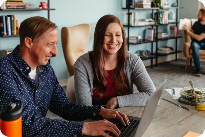 Woman and man looking at a laptop together.