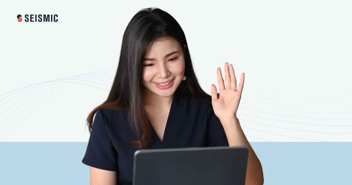 A seated woman looking down at her laptop.