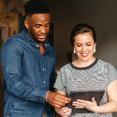 A female and male look at the screen of a tablet