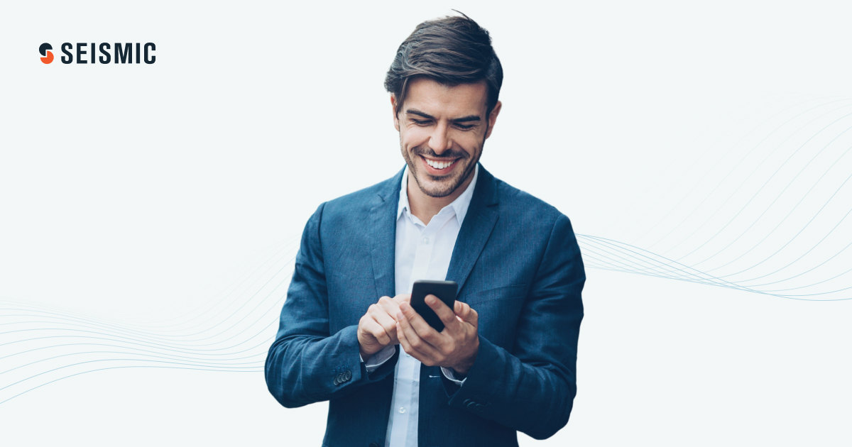 A smiling man working on his mobile phone.