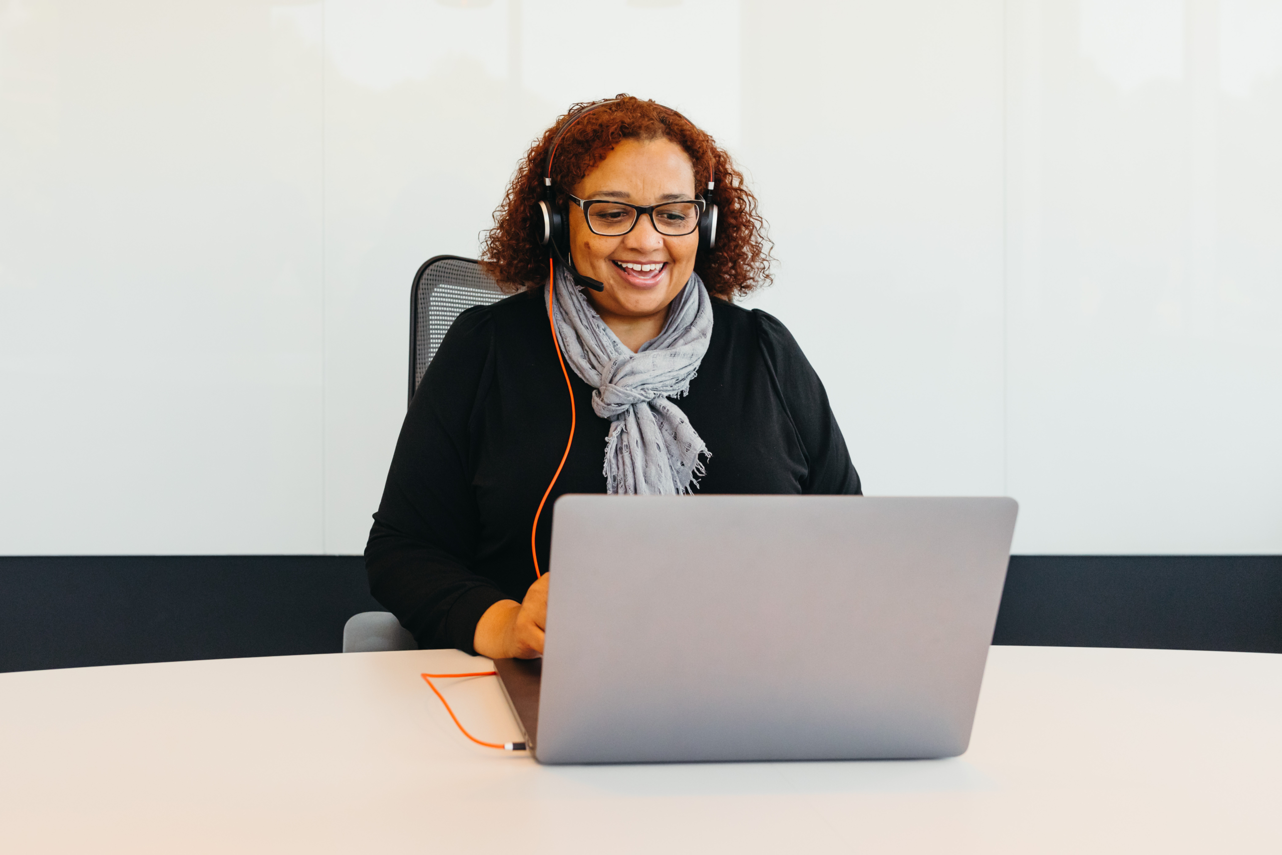 A woman seated in front of a laptop.