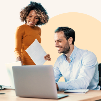 Two smiling business people looking at laptop.