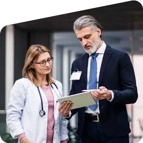 A physician and sales rep looking at information on a notebook.