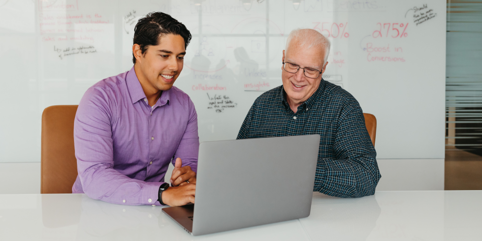 Two people working together on a laptop.