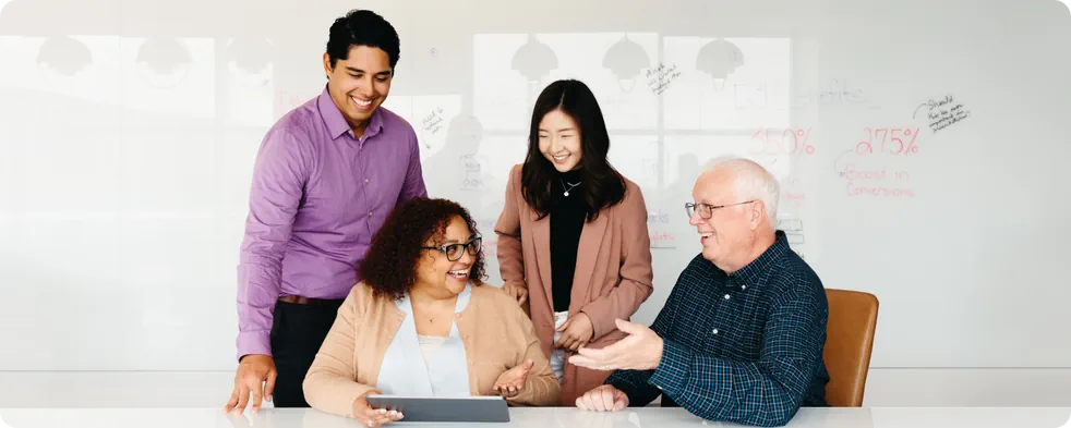 A diverse group of people laughing as they work together