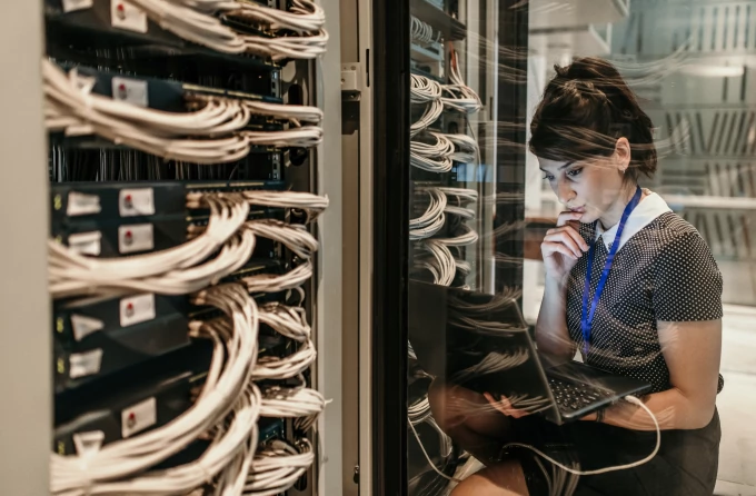 A female IT engineer working in a server room.