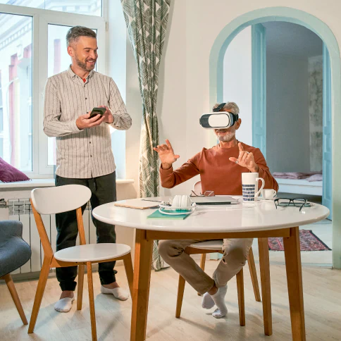 A person seated at a table wearing VR googles.