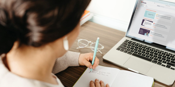 A woman writing at her desk.