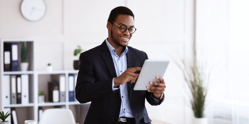 A smiling business man using a tablet